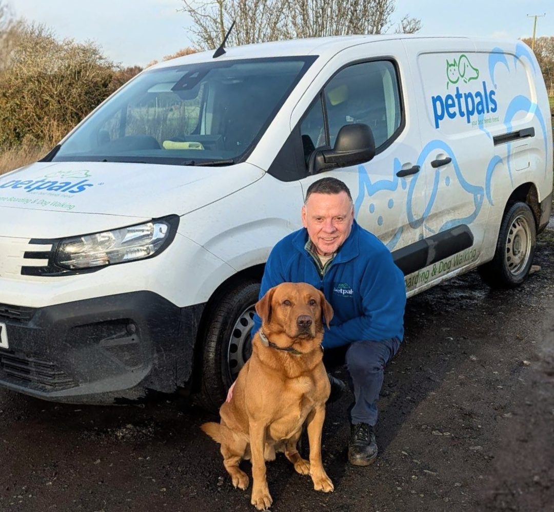 Andy, owner of Petpals Halesowen stands in front of van with Labrador dog.