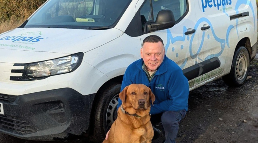 Andy, owner of Petpals Halesowen stands in front of van with Labrador dog.
